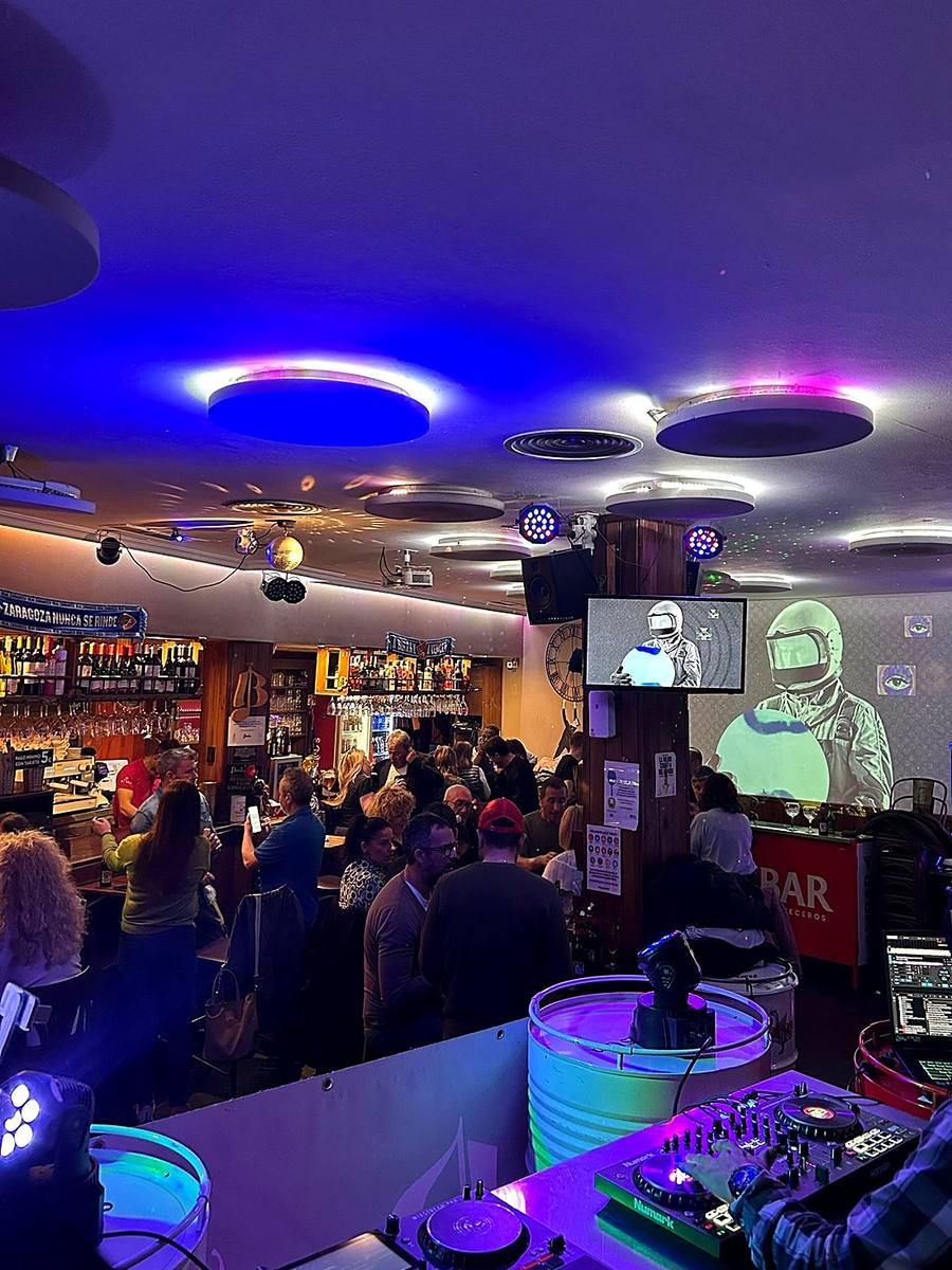Sala llena con la mesa del DJ en primer plano